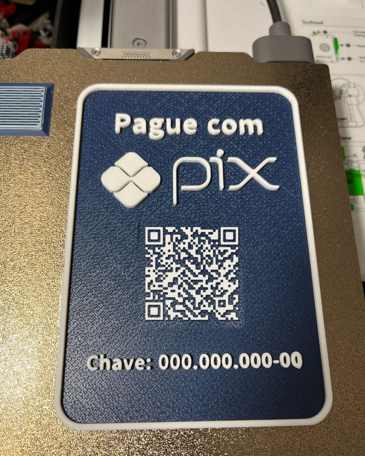 Placa azul Pague com Pix, com o logo do Pix em alto-relevo, QR Code e a chave escrita embaixo