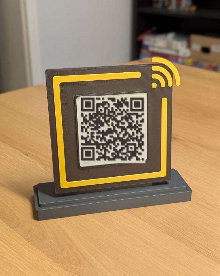 Placa quadrada de Wi-Fi em marrom e amarelo, com o símbolo de Wi-Fi no canto e o QR Code no centro, sobre uma base